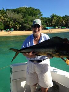 Bill Waldo smiling while holding fish on boat