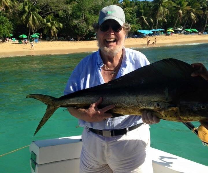 Bill Waldo smiling while holding fish on boat